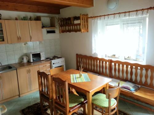 eine Küche mit einem Holztisch sowie einem Tisch und Stühlen in der Unterkunft Rekreačný domček Judka in Dedinky