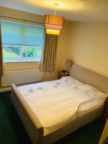 a large bed in a bedroom with a window at Beautiful double en-suite room in Oakham