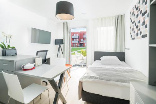 um quarto com uma cama, uma secretária e uma mesa em DASJülich em Jülich