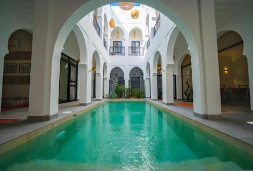 una piscina cubierta en un edificio con un arco en Riad Shanima SPA Marrakech, en Marrakech