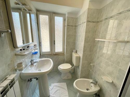 une salle de bain blanche avec un lavabo et des toilettes dans l'établissement Levanto Rentals, à Levanto