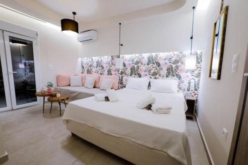 a bedroom with a large white bed and a couch at Loutraki Pinky Pearl in Loutraki