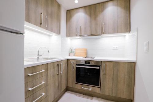 a kitchen with wooden cabinets and a sink at Loutraki Pinky Pearl in Loutraki