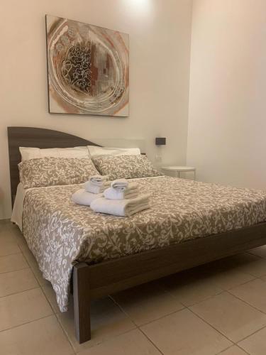 a bedroom with a bed with towels on it at Bruco Holiday in Polignano a Mare