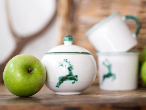 a green apple sitting next to two white vases at Gästehaus Daheim in Riezlern
