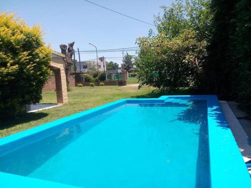 a large blue swimming pool in a yard at Casa-quinta Colastine Norte, Santa fe Argentina in Santa Fe