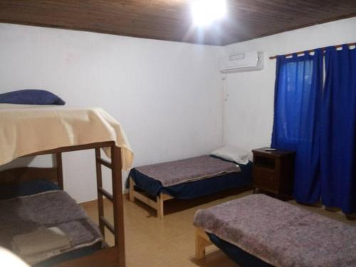 聖菲的住宿－Casa-quinta Colastine Norte, Santa fe Argentina，客房设有两张双层床和蓝色窗帘。