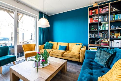 a living room with blue walls and a couch and a table at Bruist in Cadzand