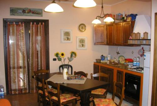 a kitchen with a table and a dining room at Baglio Makari in San Vito lo Capo