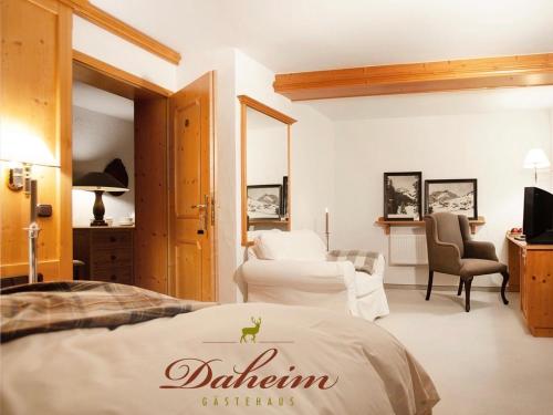 una camera d'albergo con letto e area salotto di Gästehaus Daheim a Riezlern