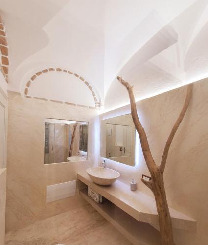 a bathroom with a sink and a tree in it at Le Andira - Monolocali finemente arredati a pochi passi dal centro storico di Orosei in Orosei