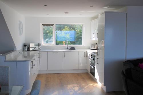 班戈北愛爾蘭的住宿－SEACLIFF ROAD APARTMENT，白色的厨房设有水槽和窗户