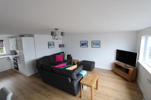 a living room with a couch and a television at SEACLIFF ROAD APARTMENT in Bangor