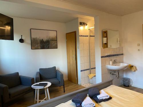 a bathroom with a couch and a sink in a room at Pension Auetal in Döhle