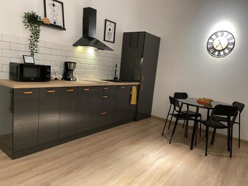 cocina con mesa y nevera negra en Old Town Superior Apartment by MRG, en Bucarest