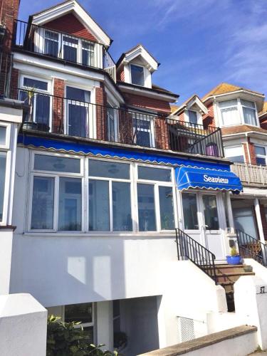 a large white building with a blue awning on it at Seaview Sanctuary in Eastbourne