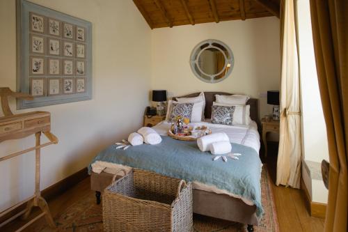 a bedroom with a bed with towels and a mirror at Quinta da Bella Vista - Historic Home and Farm in Sintra