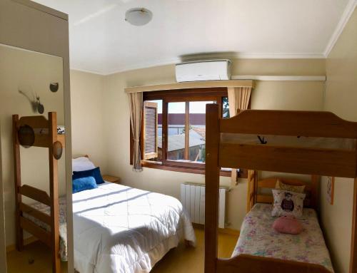 1 dormitorio con 2 literas y ventana en Apartamento completo no centro de Gramado en Gramado