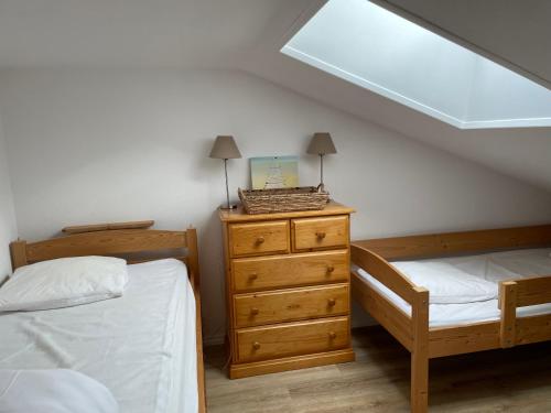 - une chambre avec 2 lits et une commode avec une fenêtre dans l'établissement Vacances en famille !, à Saint-Hilaire-de-Riez