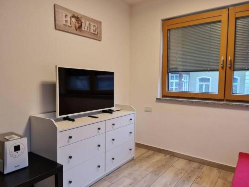 - un salon avec une commode et une télévision dans l'établissement Cityappartement am Goethepark, à Weimar