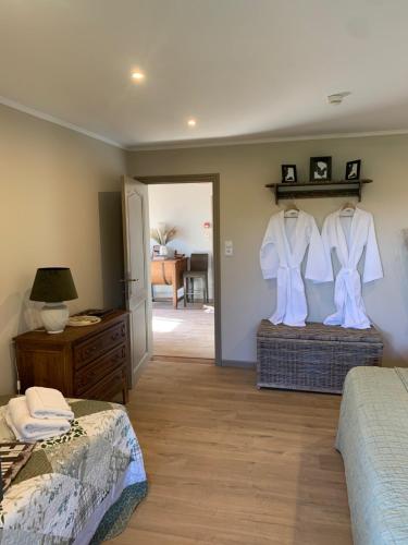 a bedroom with two beds and a dresser and a room at Le Sommelet in Somme-Leuze