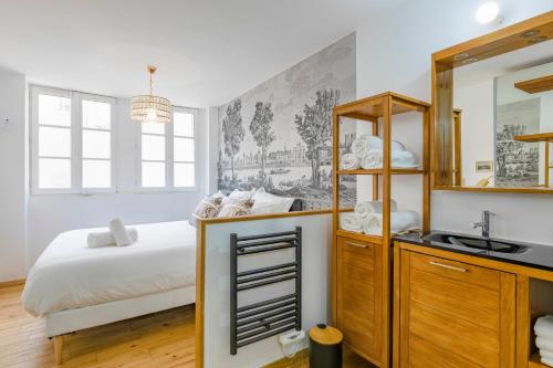 a bedroom with a bed and a sink and a mirror at LA SUITE DE L'ORANGERIE in Versailles