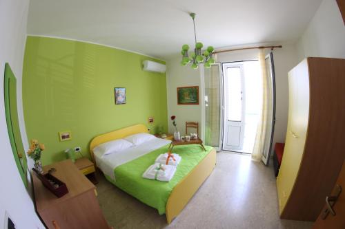 een groene slaapkamer met een bed en een raam bij Appartamento Il Gabbiano in Balestrate
