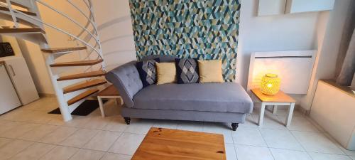 - un salon avec un canapé bleu et un escalier dans l'établissement Appartement Samuel centre ville Les Herbiers, 10 min du Puy du Fou, aux Herbiers