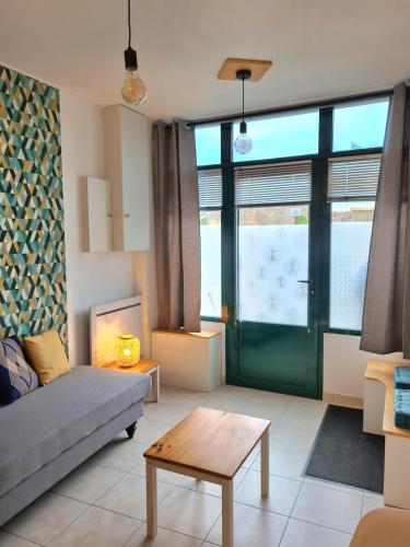 un salon avec un canapé et une table dans l'établissement Appartement Samuel centre ville Les Herbiers, 10 min du Puy du Fou, aux Herbiers