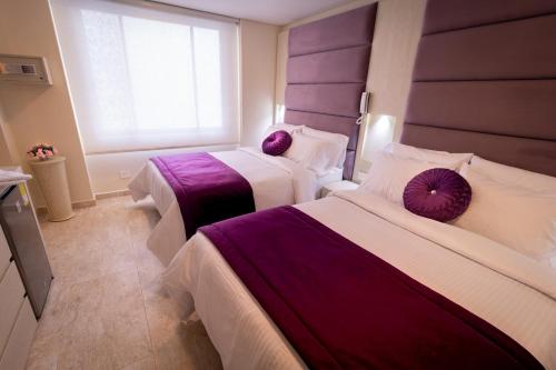 two beds in a room with purple and white at Trugo Luxury Rooms in Armenia