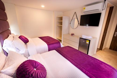 a hotel room with two beds and a tv at Trugo Luxury Rooms in Armenia