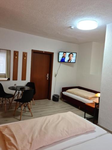 a bedroom with a bed and a tv on the wall at Pension Kreihe im Harz in Bad Lauterberg
