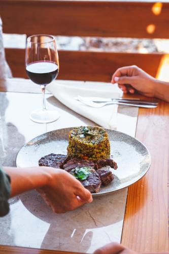 a plate of food and a glass of wine on a table at Tantakuy Eco Experience Hotel in La Huaica