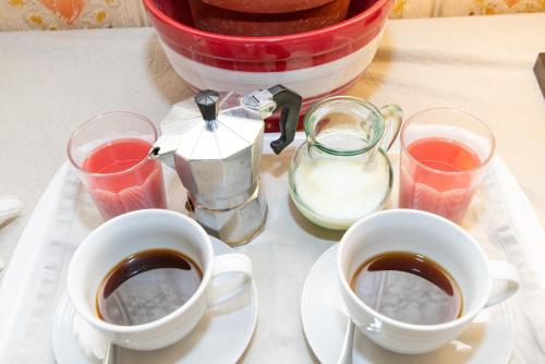 two cups of coffee sitting on a table with drinks at Maria Townhouse Heart of Victoria B&B in Victoria