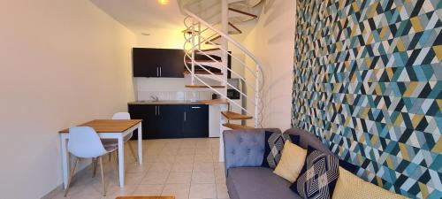 ein Wohnzimmer mit Couch und Tisch und eine Küche in der Unterkunft Appartement Samuel centre ville Les Herbiers, 10 min du Puy du Fou in Les Herbiers