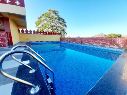 a swimming pool with blue water in a building at Pushkar Retreat Resort - The Nature and Mountain View Resort ,Pushkar in Pushkar