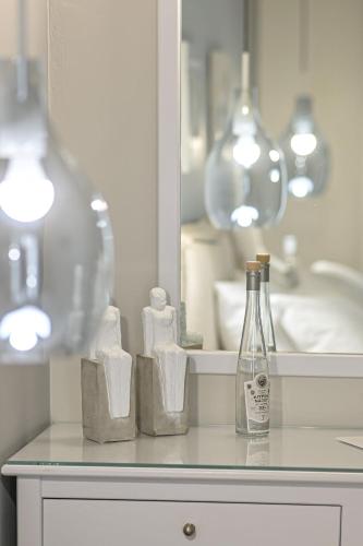 a bathroom counter with a bottle and some towels at Hotel Grotta in Naxos Chora