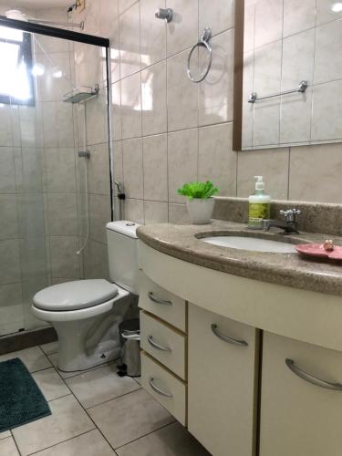 W łazience znajduje się toaleta, umywalka i prysznic. w obiekcie Apartamento Peracanga com Wi-Fi w mieście Guarapari