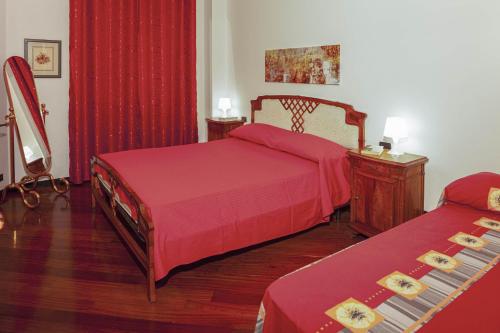 een slaapkamer met 2 bedden met rode dekens en een tafel bij Fernanda Apartment - Levanto in Levanto