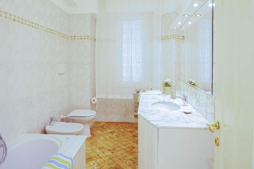 een witte badkamer met 2 wastafels en een toilet bij Fernanda Apartment - Levanto in Levanto