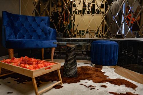 ティラナにあるRose Boutique Hotelの青い椅子とテーブルが備わる客室です。
