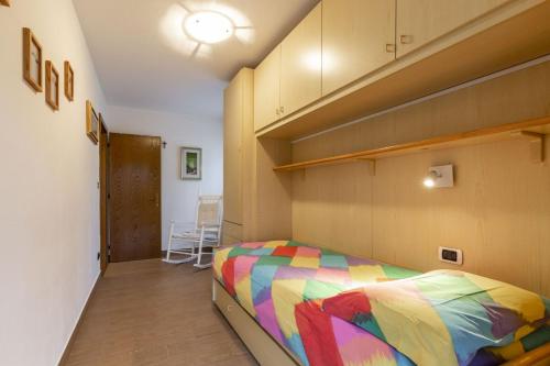 a bedroom with a bed with a colorful blanket at Val Fassa in Campitello di Fassa