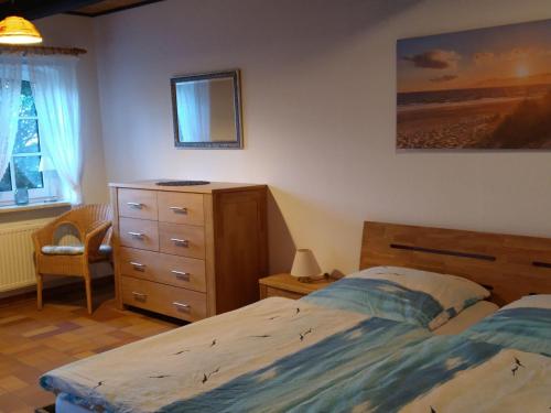 1 Schlafzimmer mit 2 Betten, einer Kommode und einem Spiegel in der Unterkunft Ferienwohnung auf dem Land in Garding