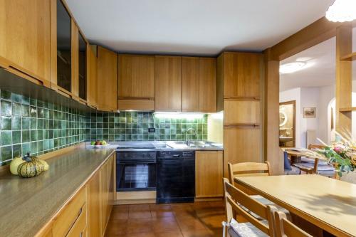 a kitchen with wooden cabinets and a table with a counter at Val Fassa in Campitello di Fassa