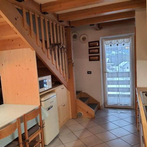a kitchen with a spiral staircase in a house at Val Fassa in Campitello di Fassa