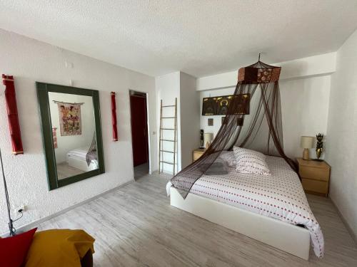 une chambre avec un lit à baldaquin dans l'établissement Villa Naturiste Port Nature, au Cap d'Agde