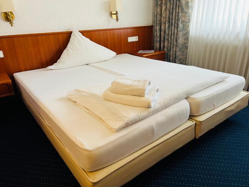 a bedroom with a bed with two towels on it at Hotel Weller Kahl am Main in Kahl am Main