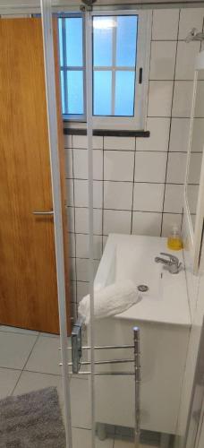 a bathroom with a white sink and a window at Casa da Isabel in São Roque do Pico