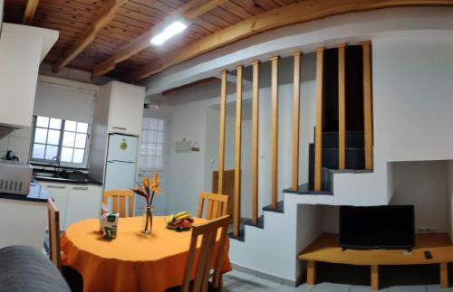 a kitchen and dining room with a table and a staircase at Casa da Isabel in São Roque do Pico