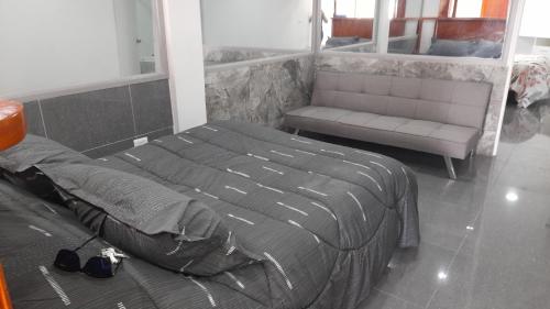 1 dormitorio con 1 cama, 1 sofá y 1 silla en Casa frente a cavancha en Iquique
